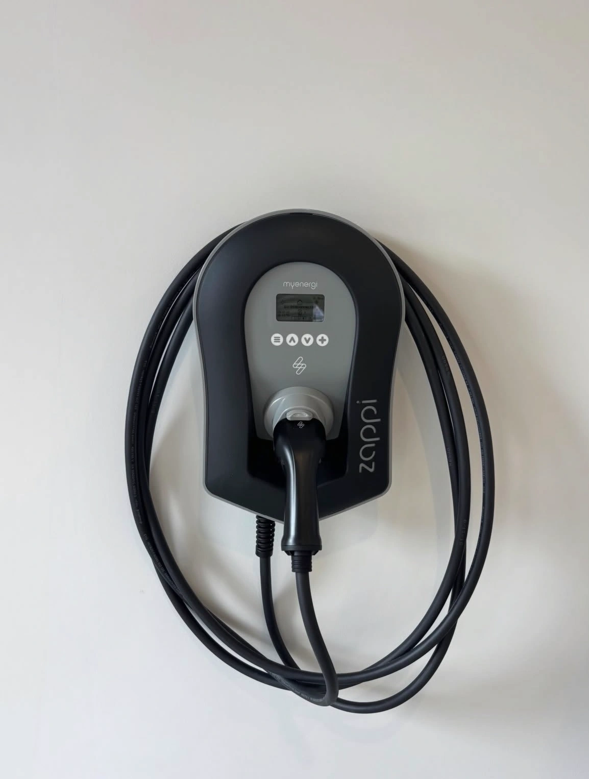 Black Zappi EV charger installed on a white wall